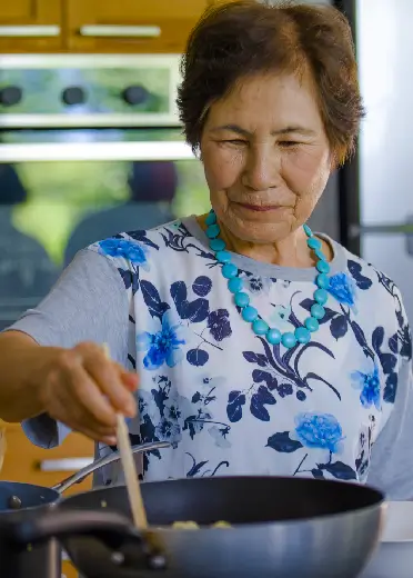 Imagen de una adulta mayor cocinando